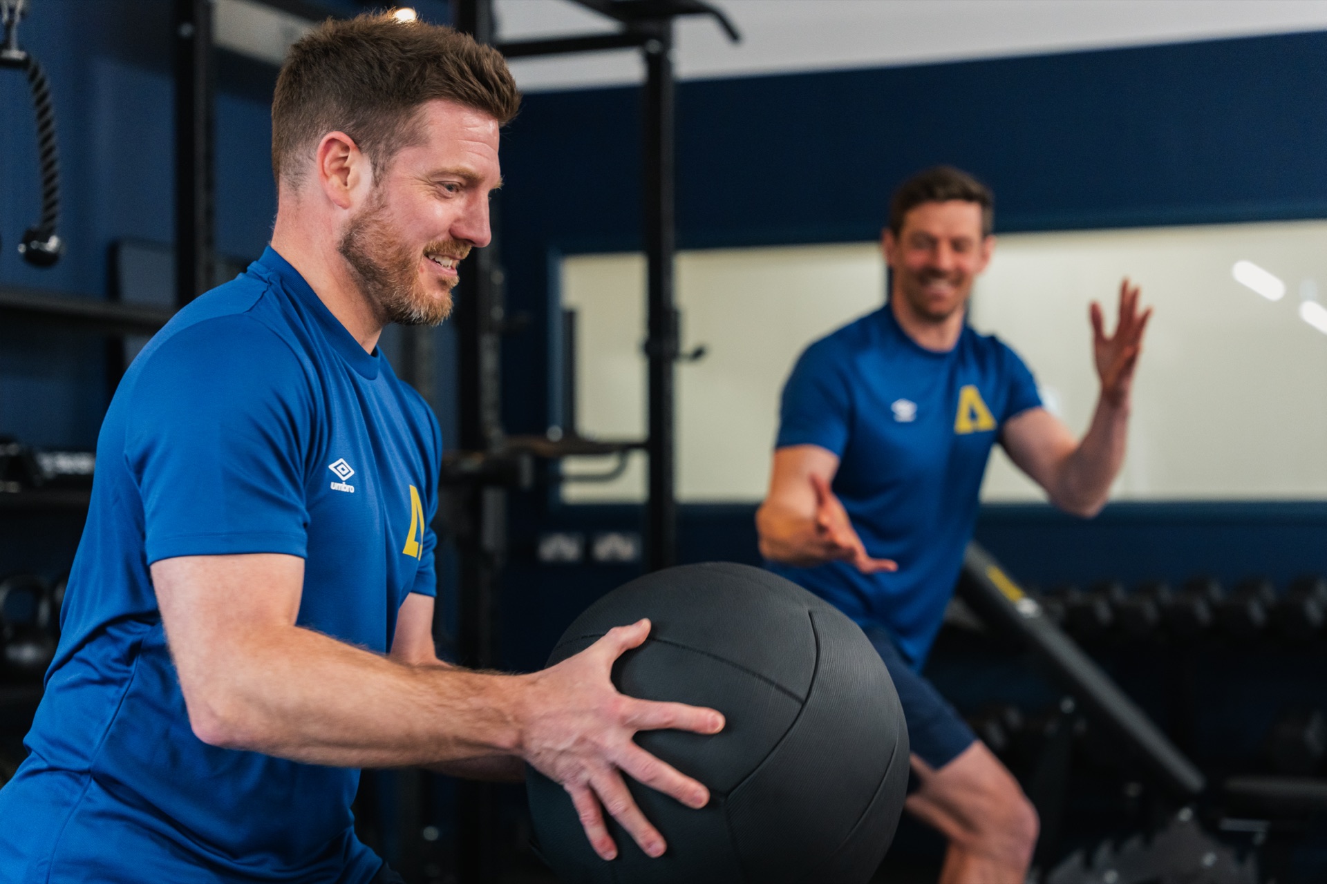 Ascension performance coach catching a medicine ball during a training session
