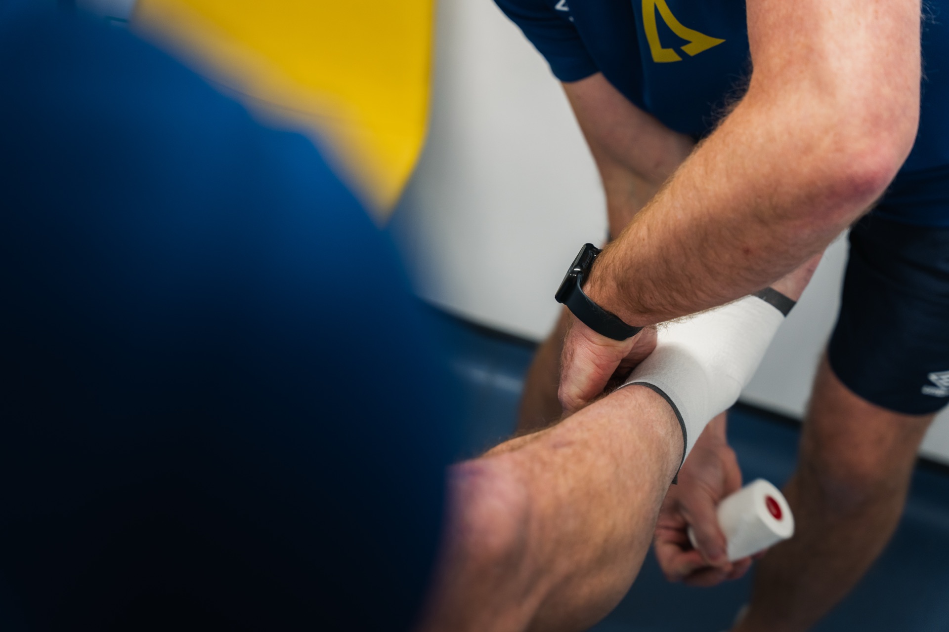 Practitioner applying strapping to an athlete's wrist at Ascension Physiotherapy & Performance