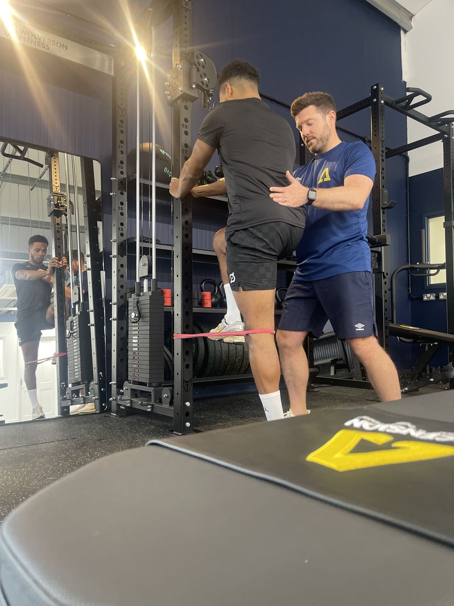 Coach guiding an athlete through a rehabilitation exercise at Ascension Physiotherapy & Performance