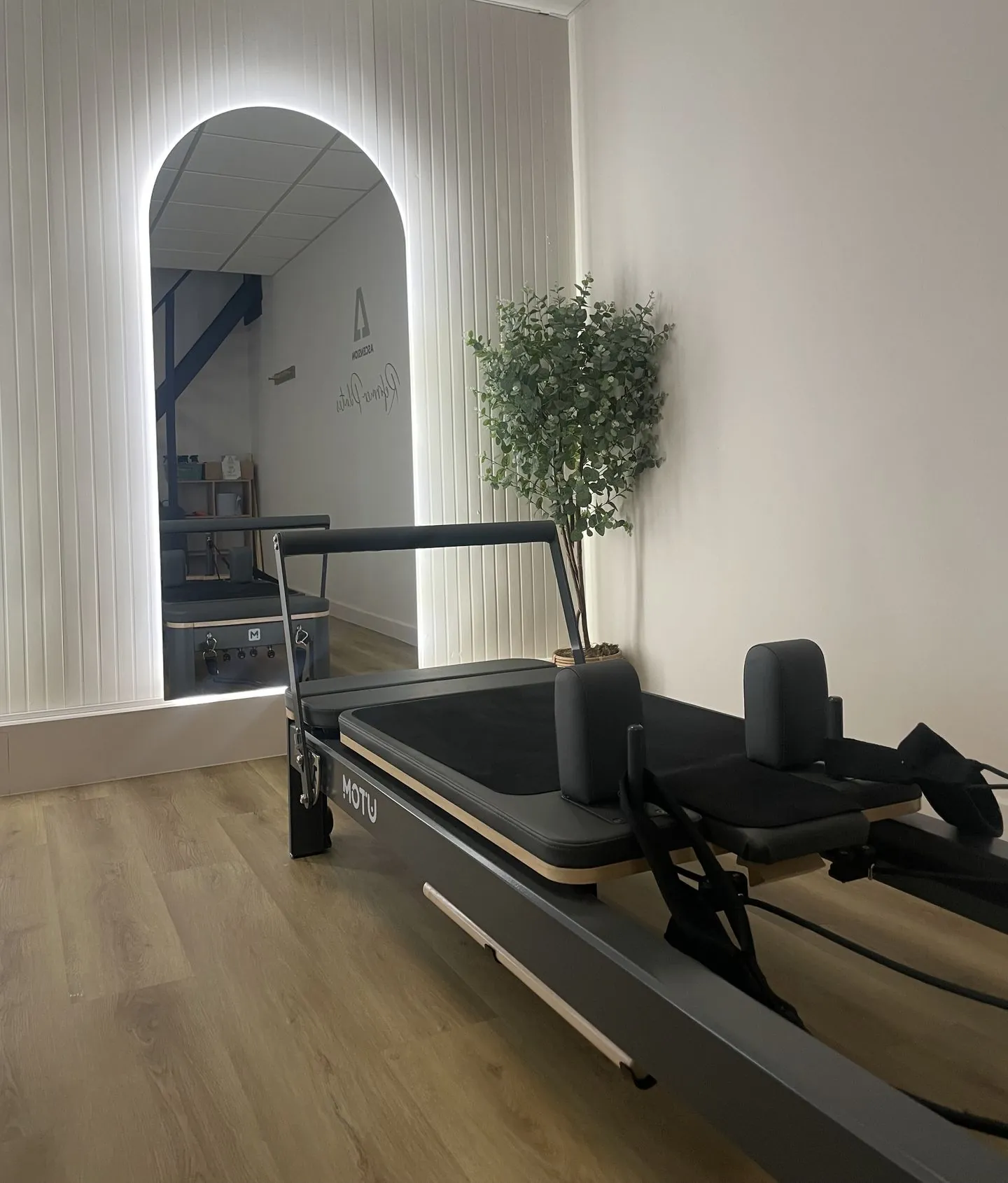 Close-up of a reformer at the Ascension studio, showing the padded carriage, shoulder rests and straps