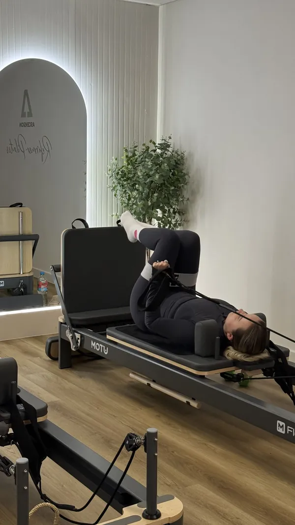 Client mid-exercise on a reformer bed